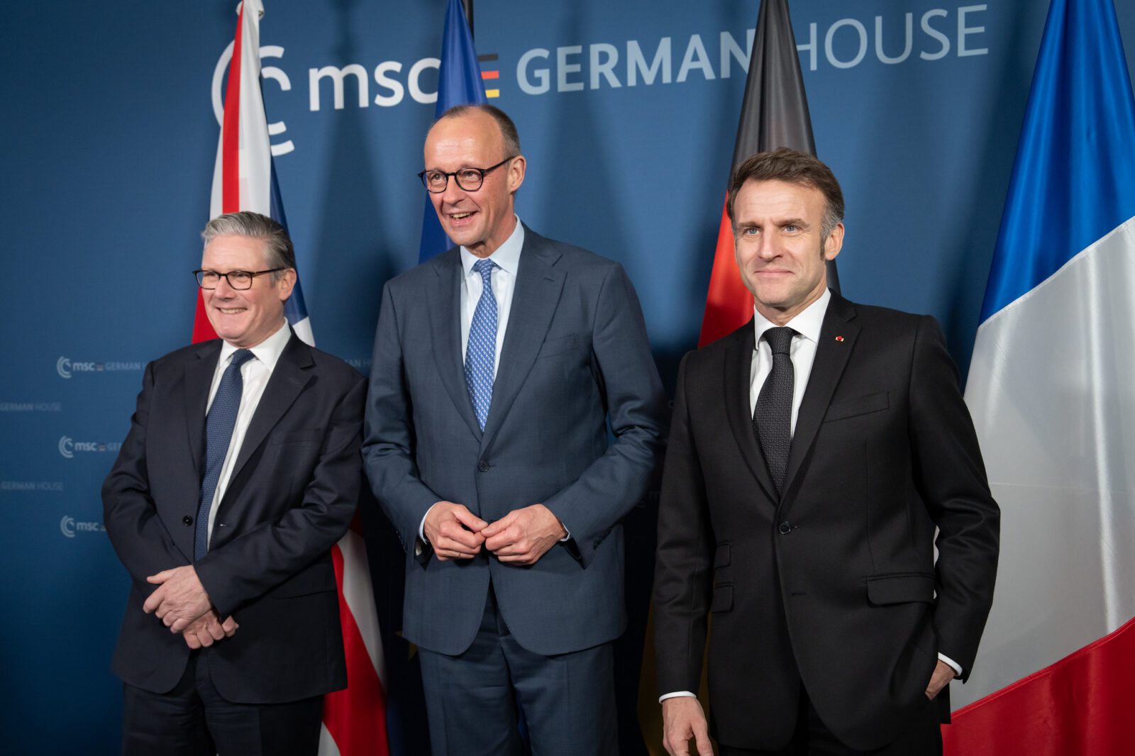 From left to right, British PM Keir Starmer, German Chancellor Friedrich Merz, and French President Emmanuel Macron stand together for a photo at the Munich Security Conference.