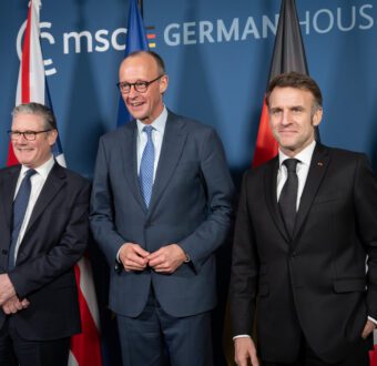 From left to right, British PM Keir Starmer, German Chancellor Friedrich Merz, and French President Emmanuel Macron stand together for a photo at the Munich Security Conference.