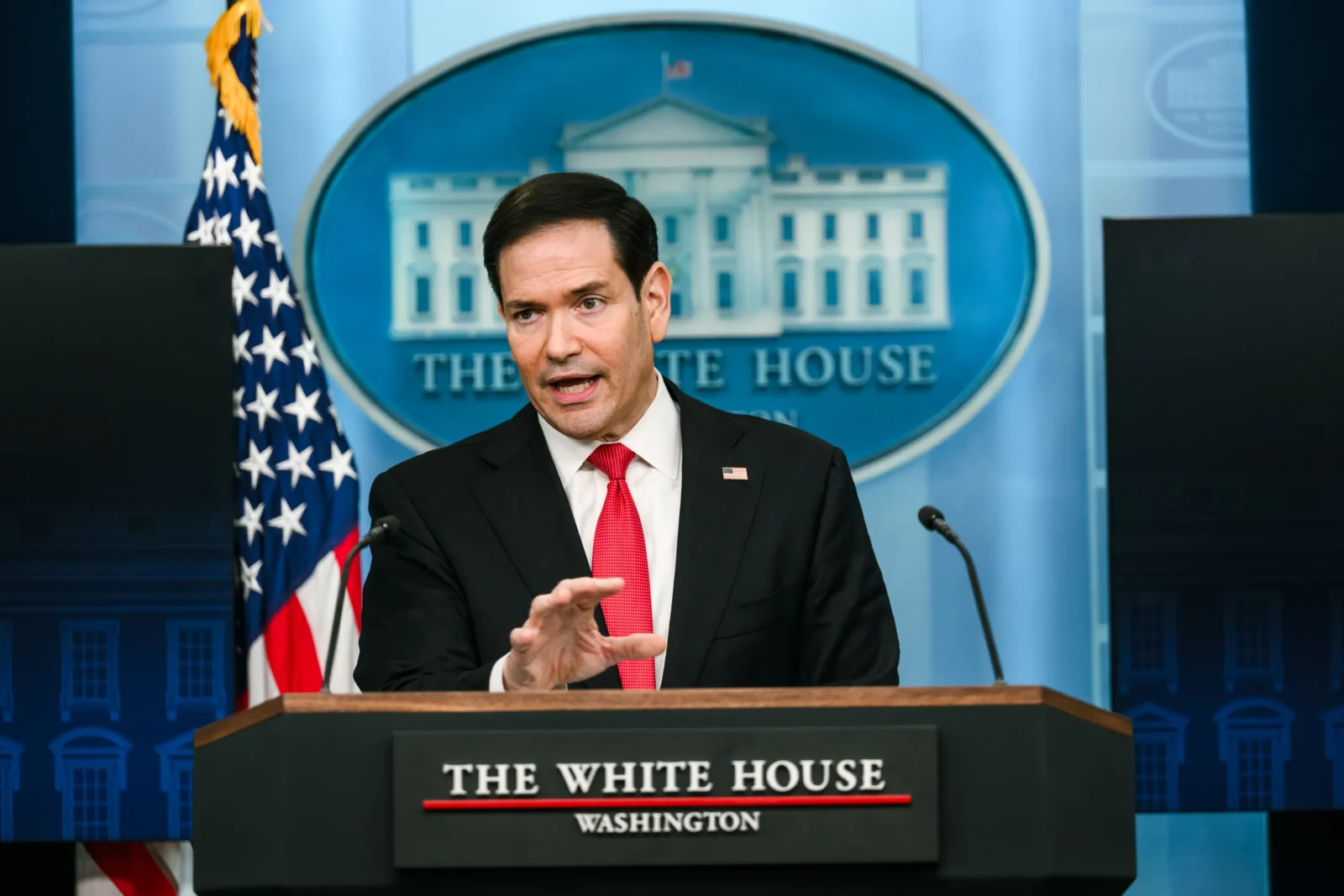 Secretary of State Marco Rubio addresses the press from a podium at the White House.