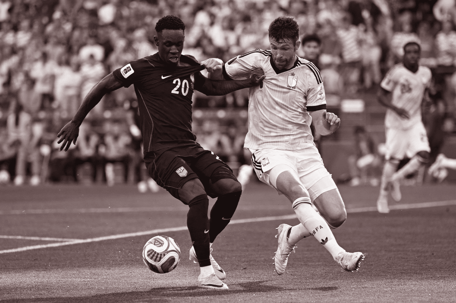 Two soccer players fight for control of the ball in the US v Belgium game.