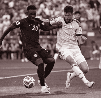 Two soccer players fight for control of the ball in the US v Belgium game.